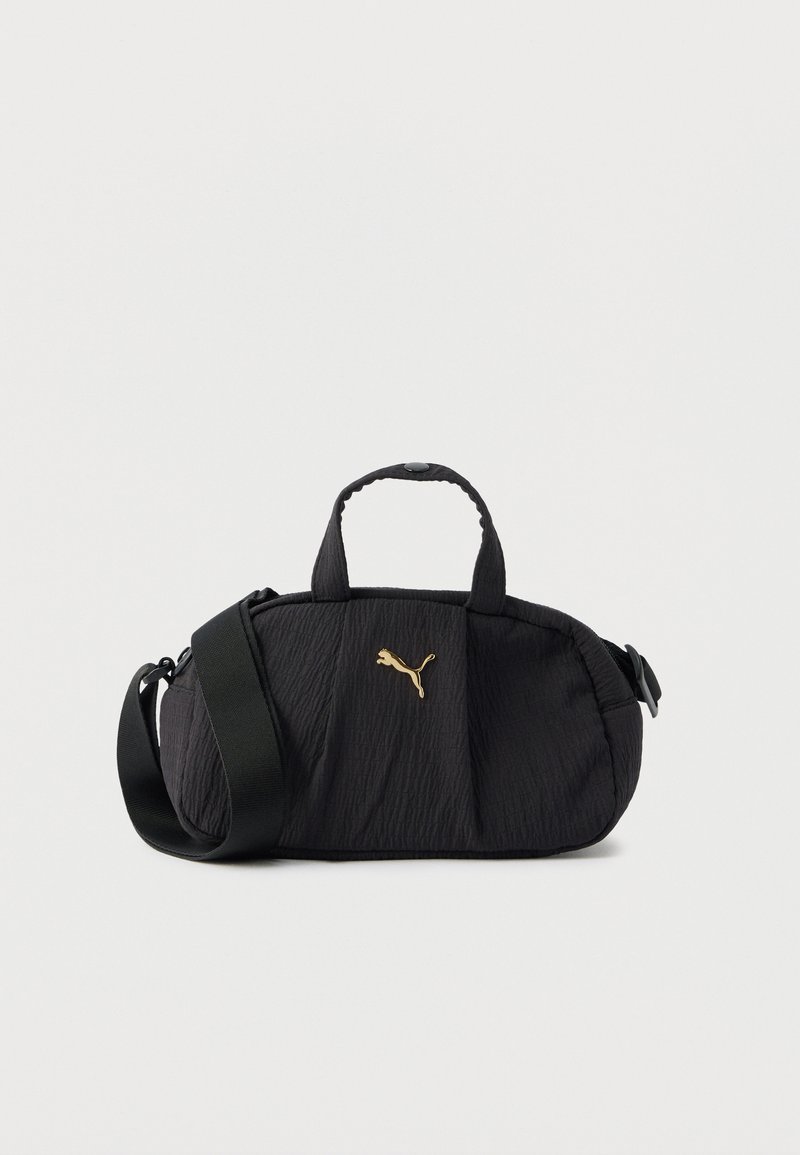 Sac bandoulière texturé noir avec poignées supérieures, large sangle réglable et petit logo Puma doré centré à l'avant.