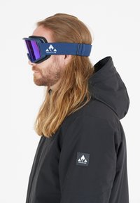 Hiihtolasit tummansinisen säätöremmin, peililinssit violetit ja vaahtomuovipaddingit. Käytetään mustan hupparin kanssa, jossa on logo.