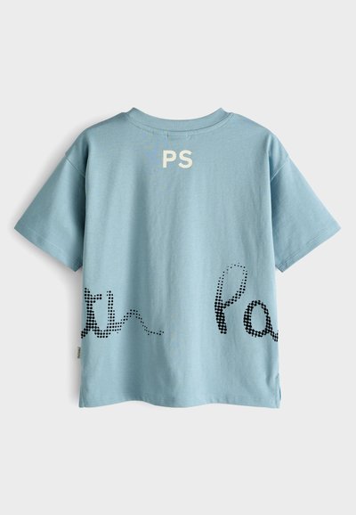 Gaiši zils īsām piedurknēm T-krekls ar melniem punktveida teksta dizainu un "PS" logo aizmugurē. Mīksta auduma un relaksēta piegriezuma.