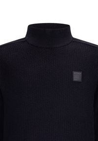 Maglione a collo alto nero con un motivo testurizzato e un piccolo etichetta quadrata sul petto sinistro. Il colletto e i polsini a coste arricchiscono il design.
