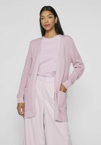 Cardigan lavorato a maglia rosa chiaro con polsini e orlo a coste, caratterizzato da un'apertura frontale e due tasche anteriori, abbinato a un top coordinato.