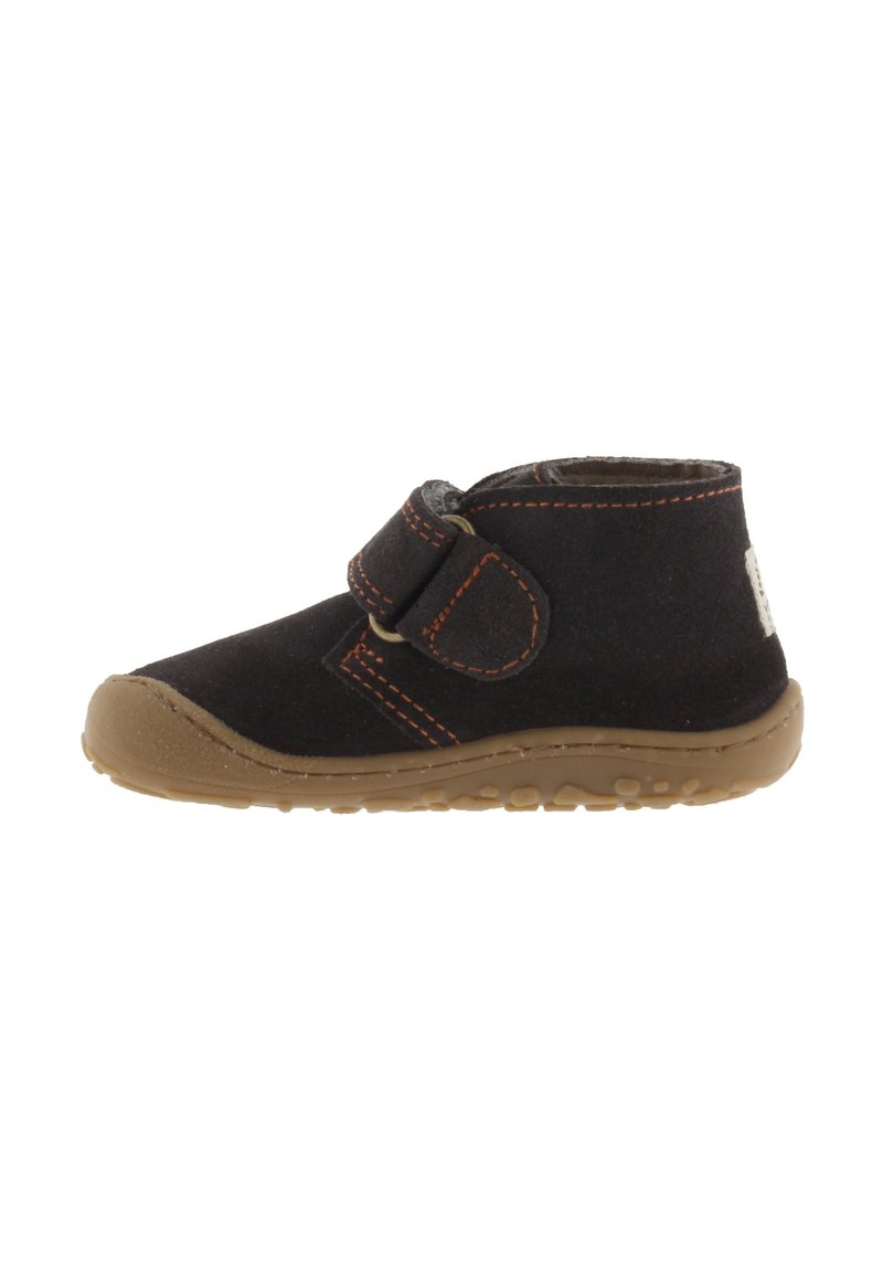 Zwarte vilten enkelschoenen met een klittenbandsluiting, contrasterende oranje stiksels en een flexibele bruine rubberen zool, ontworpen voor comfort en ondersteuning.