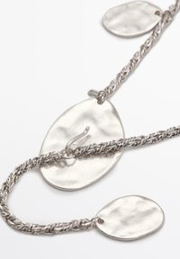 Silver braided chain with two oval pendants; one has a hook closure. Pendants feature a hammered texture and polished finish.
