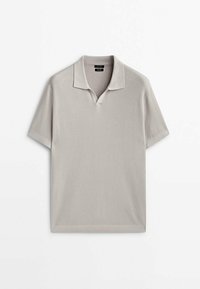 Polo à manches courtes en gris clair, en tissu tricoté texturé. Présente un col et une légère ouverture en V. Design épuré et minimal.