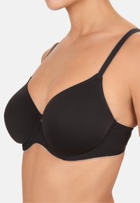 Soutien-gorge noir à armatures avec des bonnets lisses et moulés, des bretelles réglables et de subtils accents argentés le long de la bande. Présente un design épuré.