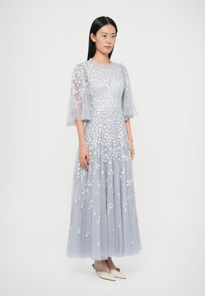 Jasnoszara sukienka z tiulu z kwiatowym haftem, krótkimi falbanianymi rękawami i rozkloszowanym dołem. Górna część jest dopasowana, podkreślając sylwetkę.