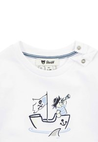 T-shirt bianco in cotone con grafica di una barca. Presenta un orso con un cappello da pirata, che tiene un telescopio, una bandiera blu e un design di un'ancora. Chiusure a pressione.