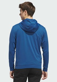 Modrá dlouhý rukáv mikina s kapucí z texturované látky, s kapucí a volným střihem. Lem a manžety jsou přiléhavé, bez viditelných vzorů.