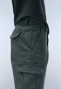 Grey cargo pants made from lightweight fabric. Features include side pockets, a flap pocket at the back, and visible stitching details.