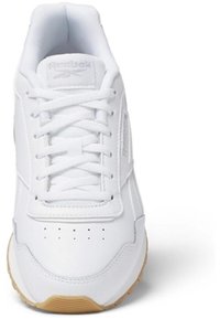 Zapatilla deportiva blanca con parte superior de cuero texturizado, cuello acolchado y suela de goma de contraste. Presenta sistema de cordones y perforaciones.