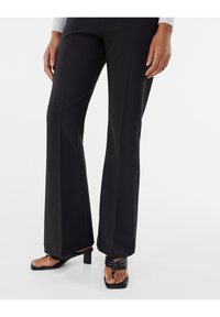 Svarta utsvängda byxor tillverkade av ett mjukt tyg, med skräddarsydd passform och en rynkfritt design. Matchad med svarta öppna klackar.