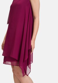 Robe sans manches magenta en mousseline légère, présentant un design à couches avec un ourlet fluide et un drapé doux.