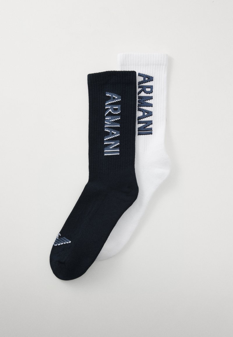 Calcetines de rayas en blanco y negro con el logotipo "ARMANI" en colores contrastantes, con un pequeño detalle de rayas cerca de la punta del calcetín negro.