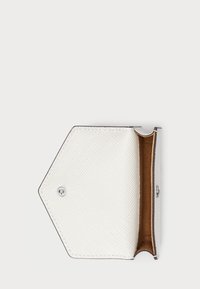Hexagonal white wallet made of textured material with a smooth brown interior. Features a silver button closure. Opened view.