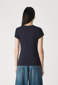 Λεπτό, κοντομάνικο μπλε t-shirt με στρογγυλή λαιμόκοψη, φτιαγμένο από μαλακό ύφασμα. Διαθέτει λεία υφή και απλό σχέδιο.