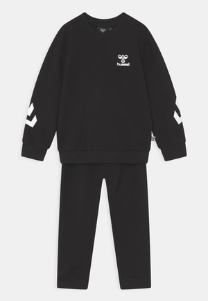 Sort træningssæt lavet af blødt materiale, der har en sweatshirt med rund hals og hvidt logo samt stribede detaljer på ærmerne, parret med matchende bukser.