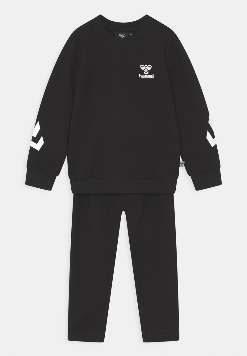 Μαύρο φόρμα από μαλακό υλικό, που περιλαμβάνει μπλούζα με στρογγυλή λαιμόκοψη και λευκό λογότυπο, καθώς και ρίγες στα μανίκια, σε συνδυασμό με ταιριαστά παντελόνια.