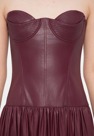 Bordové kožené šaty bez ramienok s prešívaným detailom na výstrihu, priliehavým živôtikom a rozšírenou, nazberanou sukňou.