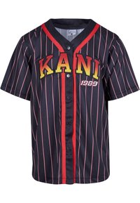 Svart kortermet jersey med røde og rosa vertikale striper, med "KANI" i gule bokstaver og "1989" i hvitt, knappelukking.