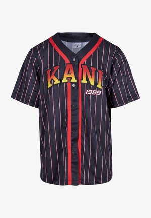 Czarna koszulka z krótkim rękawem w czerwono-różowe pionowe paski, z napisem "KANI" w żółtych literach i "1989" w białym, z zapięciem na napy.