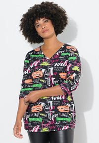 Mustat lyhyet hihansuutoppi, jossa on V-kaula-aukko ja jossa on eläviä tekstejä ja graafisia kuvioita vaaleanpunaisessa, vihreässä, oranssissa ja valkoisessa. Pehmeä ja joustava kangas.