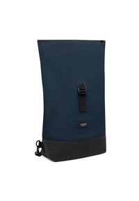 Marinblå ryggsäck med en slät yta, med en svart botten, ett blixtlås upptill och ett spännband fram.