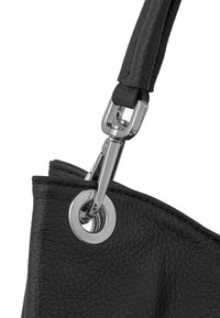 Black leather handbag detail featuring a silver metal clip and grommet. The leather has a textured finish and a stitched seam.