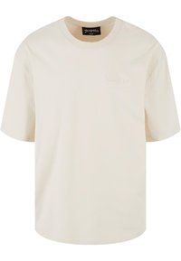 T-shirt en coton crème à manches courtes, col rond et étiquette brodée "Dropsize" à l'avant. Design simple et décontracté.