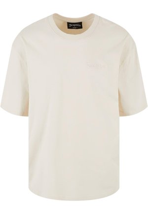 T-shirt en coton crème à manches courtes, col rond et étiquette brodée "Dropsize" à l'avant. Design simple et décontracté.