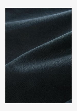 Mörkblått tyg med en slät textur som uppvisar subtila vågor. Materialet verkar stretchigt med en lätt lyster.