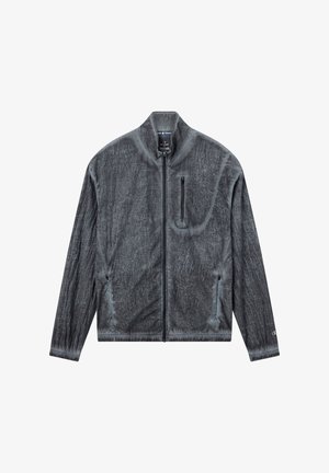 Grijze ritssluitingjas met een gestructureerde afwerking, staande kraag en een borstzak. Voorzien van elastische manchetten en een getailleerd ontwerp.