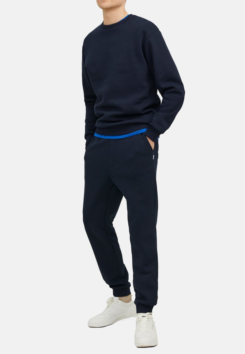 Navy blauwe sweatshirt met ronde hals en ribgebreide manchetten, gecombineerd met bijpassende joggers met een elastische tailleband en zijzakken.