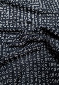 Tessuto blu scuro con un motivo ripetuto delle parole "Armani Exchange" in un grigio più chiaro, con una finitura morbida e texture.