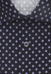 Zwarte shirt met een lichtblauw ruitpatroon, voorzien van een knoopsluiting. De stof is gestructureerd met een gladde afwerking.