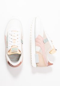 Baskets de sport présentant un mélange de blanc, beige et couleurs pastel. Fabriquées en tissu et en daim, avec une semelle texturée et un avant à lacets.