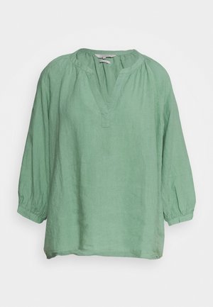 Blouse à manches longues vert menthe avec poignets froncés et encolure en V fendue, en tissu léger, présentée sur fond blanc.
