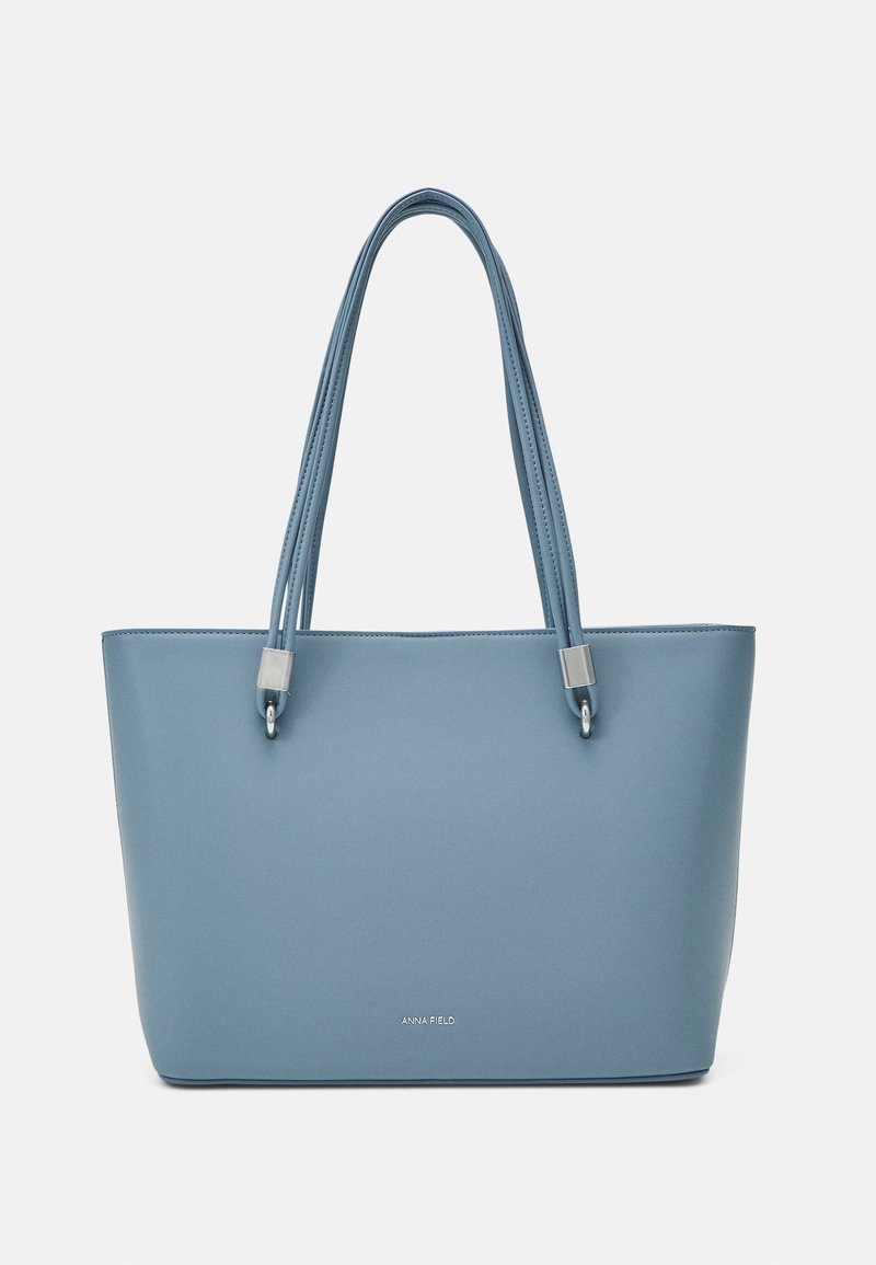 Sac cabas en cuir bleu avec double poignée et petits détails métalliques, marqué du logo "Anna Field" au centre devant.