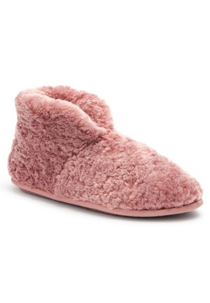 Pink blød hjemmesko, som går op til anklen, med en blød, tekstureret yderside og en flad sål designet til indendørs brug.