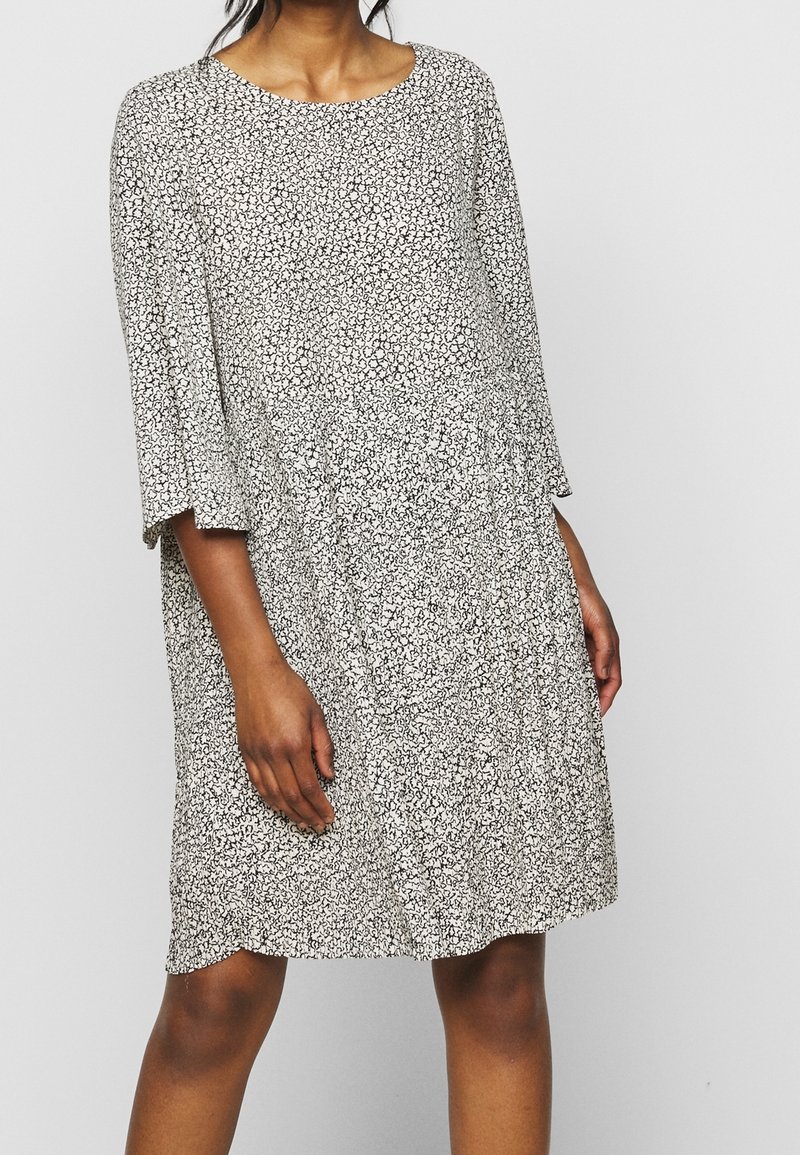 Mekko, jossa on mustavalkoinen kuviointi, pehmeä tuntuma, pyöreä pääntie ja kolmen neljänneksen kellohihat. A-linjainen muotoilu ja rento istuvuus.