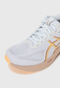 Lightweight running shoe featuring a breathable white mesh upper, yellow and brown accents, and a soft peach outsole with "FF Blast" branding.