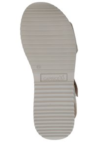 Suola della sandaletta Caprice in gomma, con texture a strisce orizzontali, di colore beige, con logo del brand e indicazione della taglia.