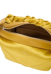 Keltainen käsilaukku, jossa on punottu yläosa, valmistettu sileästä nahasta. Varustettu vetoketjulla ja ruskealla sisustalla, jossa on useita taskuja.