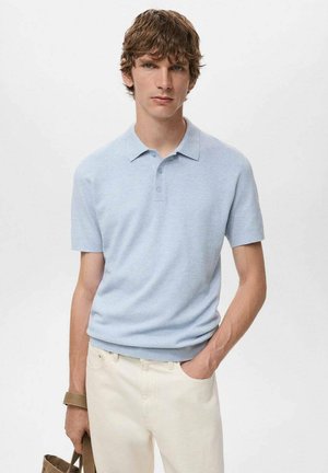 Camisa polo de manga corta azul claro hecha de una tela texturada, con un cuello tradicional y una tapeta de tres botones, combinada con pantalones color crema.