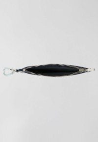 Borsetta in pelle nera con forma sottile e allungata e cerniera in tonalità oro. Presenta un attacco a clip trasparente. Texture liscia in tutto il suo corpo.