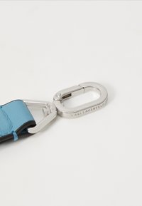 Brățară din piele de culoare albastru deschis, cu un închizător metalic argintiu, care are o textură netedă și un logo embosat pe componenta metalică.