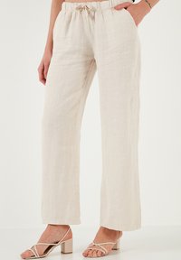 Linnen, beige broeken met een elastische tailleband en een trekkoord; wijde pijpen, met een zachte textuur en minimale stikdetails.