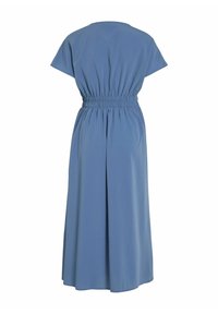 Hame sininen, nesteenomainen mekko, jossa on lyhyet hihat, kerätty joustava vyötärö ja pitkä, virtaava helma. Sujuva pinta, minimalistinen muotoilu.