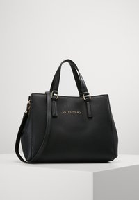 Borsa a mano in pelle nera con finitura texture, doppi manici superiori, tracolla rimovibile, dettaglio del logo oro e forma strutturata.
