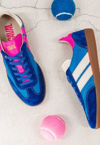 Chaussures de sport bleues et roses avec des bandes blanches sur une surface blanche texturée, accompagnées d'une balle de tennis bleue et d'une rose.