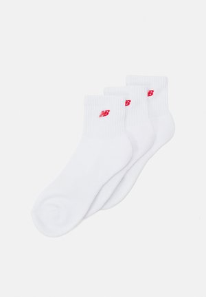 Set di calzini alla caviglia in cotone bianco, con polsino a costine e un piccolo logo rosso su ciascuno. Tessuto liscio con una forma standard per calzini.
